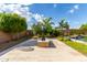 A well-manicured backyard with stone pavers, desert landscaping, a modern gas fireplace, and a lush green lawn at 2308 E Dry Wood Rd, Phoenix, AZ 85024