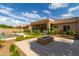 Backyard featuring desert landscaping, a modern gas fireplace, a lush green lawn and beautiful pool in the background at 2308 E Dry Wood Rd, Phoenix, AZ 85024