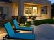 The covered patio overlooks the lush turf in the backyard, complete with outdoor kitchen and comfortable seating at 2308 E Dry Wood Rd, Phoenix, AZ 85024