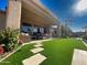 Covered patio with a complete outdoor kitchen with lush turf, and travertine tile in this meticulously landscaped backyard at 2308 E Dry Wood Rd, Phoenix, AZ 85024