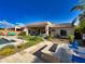 Beautiful backyard with a pool, fire pit, travertine tile and lush landscaping under a clear blue sky at 2308 E Dry Wood Rd, Phoenix, AZ 85024