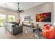 Cozy living room boasting a modern ceiling fan, leather sofa, and bright accents at 2308 E Dry Wood Rd, Phoenix, AZ 85024