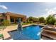 Inviting swimming pool featuring clear blue water, an umbrella, lush landscaping, and a view of the home's exterior at 2308 E Dry Wood Rd, Phoenix, AZ 85024