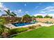 Inviting backyard pool with water features, lush landscaping, and comfortable lounge chairs at 2308 E Dry Wood Rd, Phoenix, AZ 85024