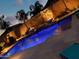 A stunning backyard pool featuring two fire bowls and vibrant lighting for a nighttime swim at 2308 E Dry Wood Rd, Phoenix, AZ 85024