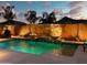 Backyard pool with two fire bowls atop a rock waterfall feature, lit for evening enjoyment at 2308 E Dry Wood Rd, Phoenix, AZ 85024