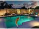 Nighttime view of backyard pool, highlighted with water feature and elegant landscaping at 2308 E Dry Wood Rd, Phoenix, AZ 85024