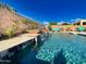 Gorgeous pool with water features, lush landscaping and elegant travertine tile accents at 2308 E Dry Wood Rd, Phoenix, AZ 85024