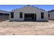 Rear exterior view with sliding glass doors and simple window trim; the backyard is yet to be landscaped at 24104 W Bowker St, Buckeye, AZ 85326