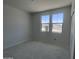 An empty bedroom, offering a bright interior with a large window and neutral walls at 24104 W Bowker St, Buckeye, AZ 85326