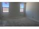 A bedroom filled with natural light from the two large windows, waiting to be customized at 24104 W Bowker St, Buckeye, AZ 85326