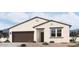 New construction home showcasing desert landscaping, a two-car garage, and a neutral color palette at 24104 W Bowker St, Buckeye, AZ 85326