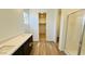 Bathroom featuring a double sink vanity with dark cabinets, a walk-in closet, and a glass-enclosed shower at 25133 W Wayland Dr, Buckeye, AZ 85326