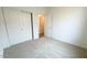Bright bedroom with neutral carpet, a closet with sliding doors and a view into the hallway through an open door at 25133 W Wayland Dr, Buckeye, AZ 85326