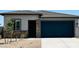 Charming single-story home featuring a blue garage door, stone accents, and a well-maintained front yard at 25133 W Wayland Dr, Buckeye, AZ 85326