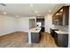 Bright kitchen boasts stainless steel appliances, an island with sink, granite countertops and beautiful hardwood style floors at 25133 W Wayland Dr, Buckeye, AZ 85326