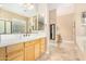 Bathroom with tiled floors, light wood cabinets, and large mirror at 26330 N 56Th Dr, Phoenix, AZ 85083