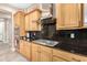 Kitchen featuring stainless steel range hood, granite countertops, and wooden cabinets at 26330 N 56Th Dr, Phoenix, AZ 85083