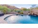 Relaxing pool area, featuring a rock waterfall and surrounded by mature trees at 26330 N 56Th Dr, Phoenix, AZ 85083
