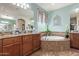 A luxurious bathroom with a soaking tub, granite countertops, and ample cabinet space for storage at 27088 W Sequoia Dr, Buckeye, AZ 85396