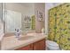 Bright bathroom with a granite countertop, decorative accents, and a colorful shower curtain adding personality at 27088 W Sequoia Dr, Buckeye, AZ 85396
