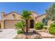 Charming home featuring a stucco exterior, clay tile roof, desert landscaping, and mature palm trees at 27088 W Sequoia Dr, Buckeye, AZ 85396