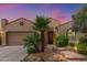 Charming home featuring a stucco exterior, clay tile roof, desert landscaping, and mature palm trees at 27088 W Sequoia Dr, Buckeye, AZ 85396