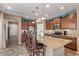 Well-lit kitchen featuring granite countertops, stainless steel appliances, breakfast bar, and stylish pendant lighting at 27088 W Sequoia Dr, Buckeye, AZ 85396
