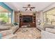 Spacious living room with tile flooring, ceiling fan, entertainment center, and natural light at 27088 W Sequoia Dr, Buckeye, AZ 85396