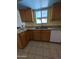 Kitchen with light oak cabinetry, stainless steel sink, tile floors, and a window above sink at 2934 W Northview Ave, Phoenix, AZ 85051