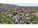 Expansive aerial view of a neighborhood with houses featuring solar panels, surrounded by lush greenery and mountain views at 2985 N Point Ridge Rd, Buckeye, AZ 85396