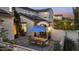 Charming backyard patio featuring pavers, seating, string lights and solar panels on the roof at 2985 N Point Ridge Rd, Buckeye, AZ 85396