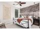 Stylish bedroom with brick accent wall, iron bed frame, and rustic-themed decor at 2985 N Point Ridge Rd, Buckeye, AZ 85396