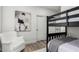 bedroom with black bunkbeds, wood floors, a white chair, and a painting on the wall at 2985 N Point Ridge Rd, Buckeye, AZ 85396