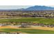 Panoramic view of the golf course with mountains in the background with a community in the distance at 2985 N Point Ridge Rd, Buckeye, AZ 85396