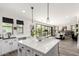 This is a beautiful white kitchen with quartz countertops, modern fixtures, stainless steel appliances, and open concept to living area at 2985 N Point Ridge Rd, Buckeye, AZ 85396