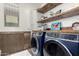 Well-organized laundry room with modern washer and dryer and rustic wood shelving at 2985 N Point Ridge Rd, Buckeye, AZ 85396