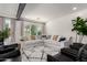 Bright living room area with big windows, modern decor, and wood-look tile flooring at 2985 N Point Ridge Rd, Buckeye, AZ 85396