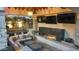 Cozy outdoor living area featuring a fireplace, multiple TVs, comfortable seating, and lush surroundings at 2985 N Point Ridge Rd, Buckeye, AZ 85396