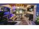 Inviting outdoor living space with a fireplace, TV, comfortable seating, and lush landscaping at 2985 N Point Ridge Rd, Buckeye, AZ 85396