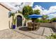 Charming outdoor patio area featuring a dining table with an umbrella and a decorative wrought iron gate at 2985 N Point Ridge Rd, Buckeye, AZ 85396