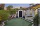 Private putting green with lush landscaping, string lights, and access to the home's side entrance at 2985 N Point Ridge Rd, Buckeye, AZ 85396