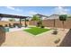 Beautiful backyard with gravel, artificial turf, and patio furniture beneath a pergola for relaxing and entertaining at 3048 W Thorn Tree Dr, Phoenix, AZ 85085