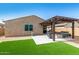 Inviting backyard featuring a pergola, fire pit, artificial turf, and patio furniture, perfect for outdoor relaxation at 3048 W Thorn Tree Dr, Phoenix, AZ 85085