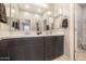 Well-lit bathroom showcasing a double vanity with dark wood cabinets, neutral walls and a large mirror at 3048 W Thorn Tree Dr, Phoenix, AZ 85085