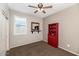 This bedroom features neutral walls, light brown carpet, and a red bookcase with a black mirror at 3048 W Thorn Tree Dr, Phoenix, AZ 85085