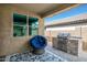 Covered patio with built in grill, decorative chair, and patterned rug that enhances outdoor living at 3048 W Thorn Tree Dr, Phoenix, AZ 85085