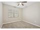 Neutral bedroom features plush carpet, natural light from window, and ceiling fan at 30776 W Earll Dr, Buckeye, AZ 85396