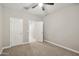 Neutral bedroom with carpet, a ceiling fan, and two doors, offering a flexible space at 30776 W Earll Dr, Buckeye, AZ 85396