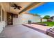 Wide shot of a covered patio leading to a barbecue and artificial grass lawn at 3819 N Springfield St, Buckeye, AZ 85396